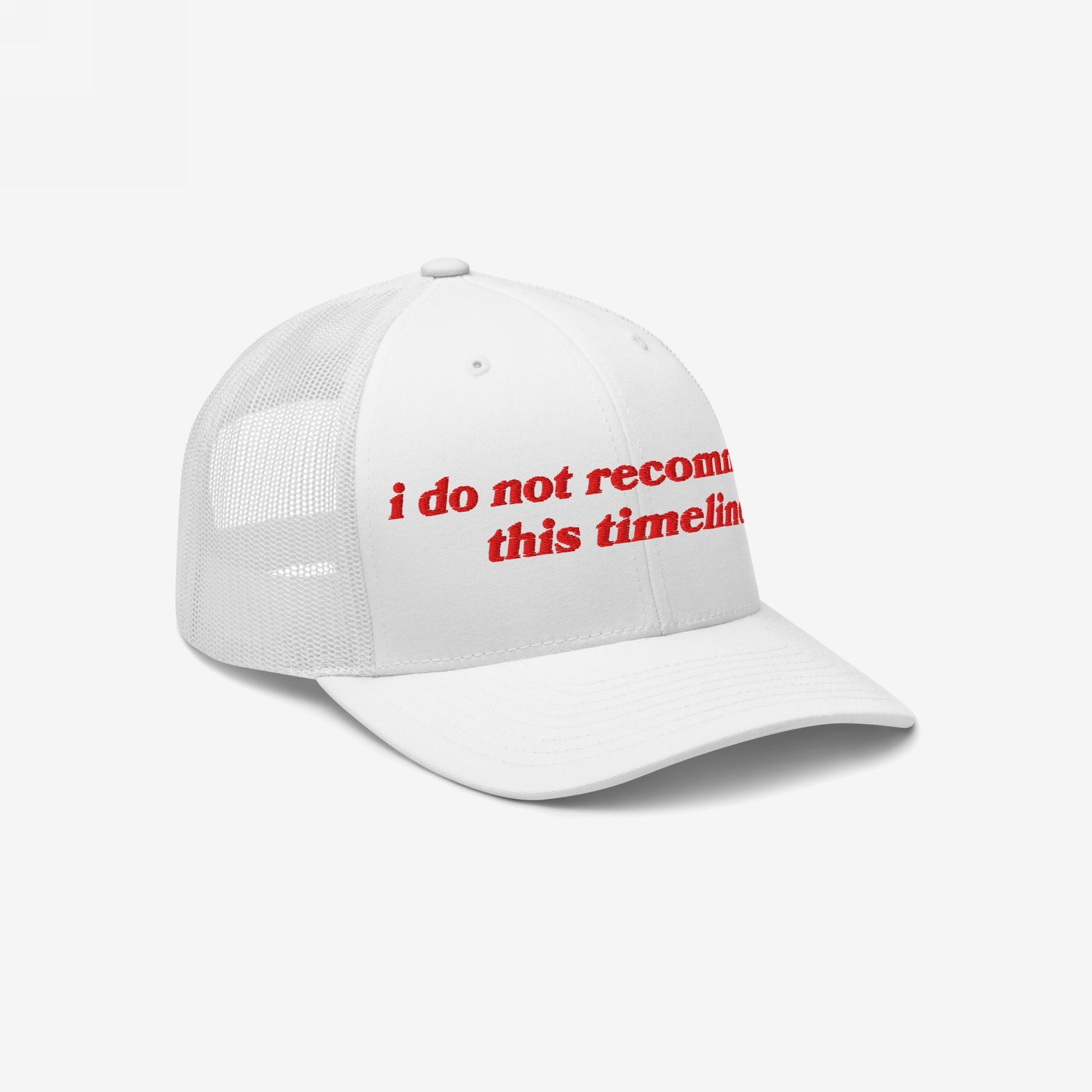 White trucker-style baseball cap featuring bold red embroidery: “i do not recommend this timeline.” Perfect for expressing modern chaos with irony, aligning with Egoproof's mental health and societal awareness themes.