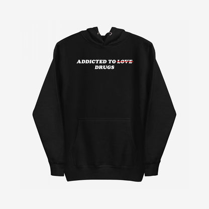 Addicted To Love / Drugs Hoodie EU features ADDICTED TO LOVE with LOVE crossed out, replaced by DRUGS below. A midweight pullover with a kangaroo pocket, embodying dark humor and emotional resilience.