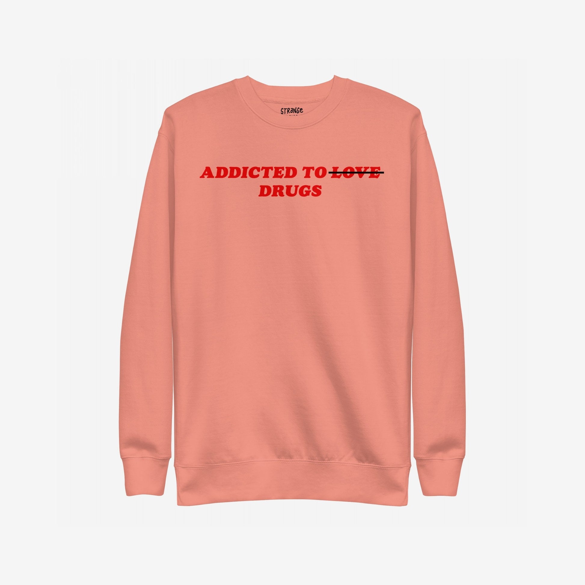 The Addicted To Love / Drugs Sweatshirt EU features bold red text on a salmon-pink crewneck, humorously striking through LOVE to highlight DRUGS, embodying Egoproof’s candid mental health messaging.