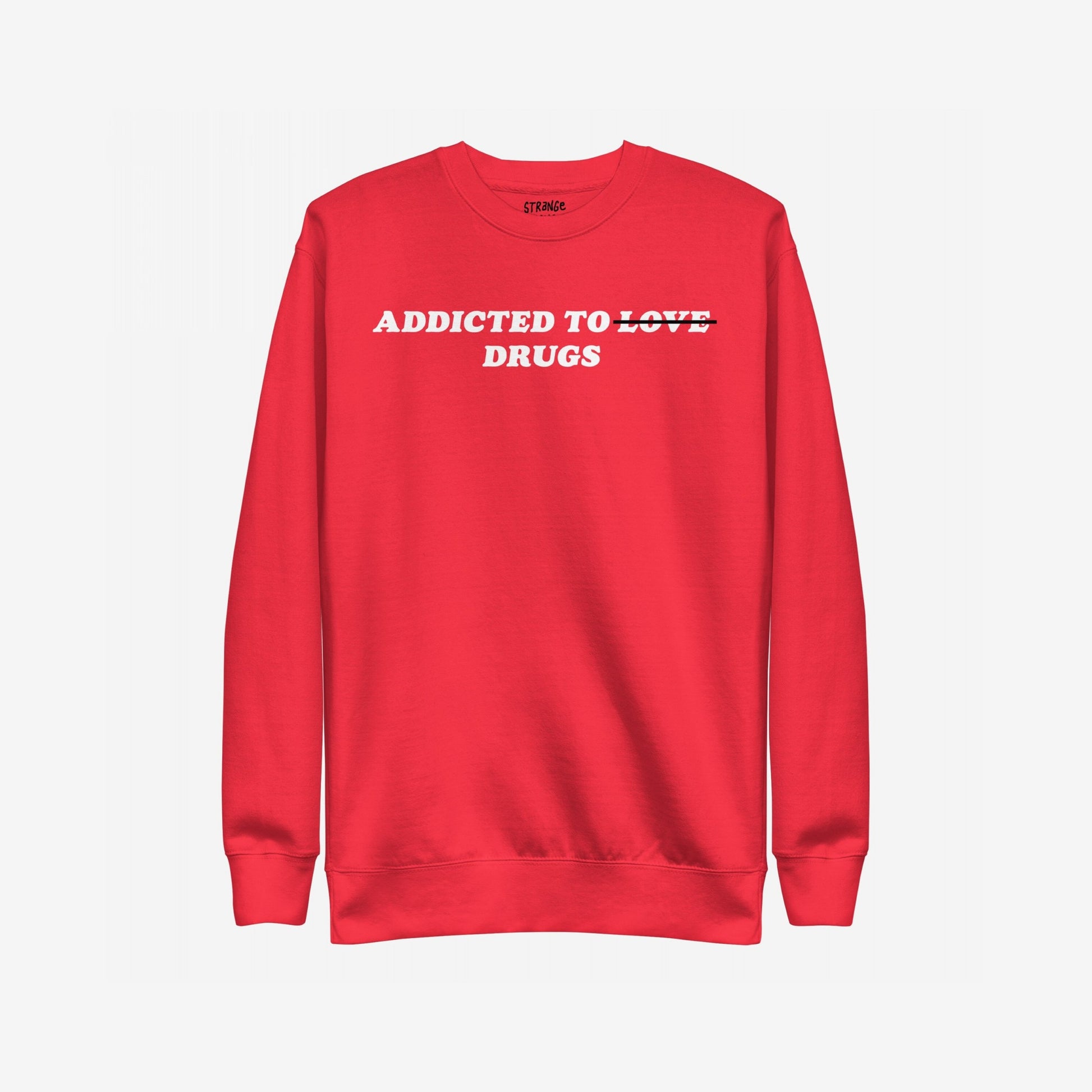 Addicted To Love / Drugs Sweatshirt EU: A red crewneck with bold text humorously altering Addicted to Love to Drugs, embodying candid mental health expression. Features a subtle label at the back neckline.