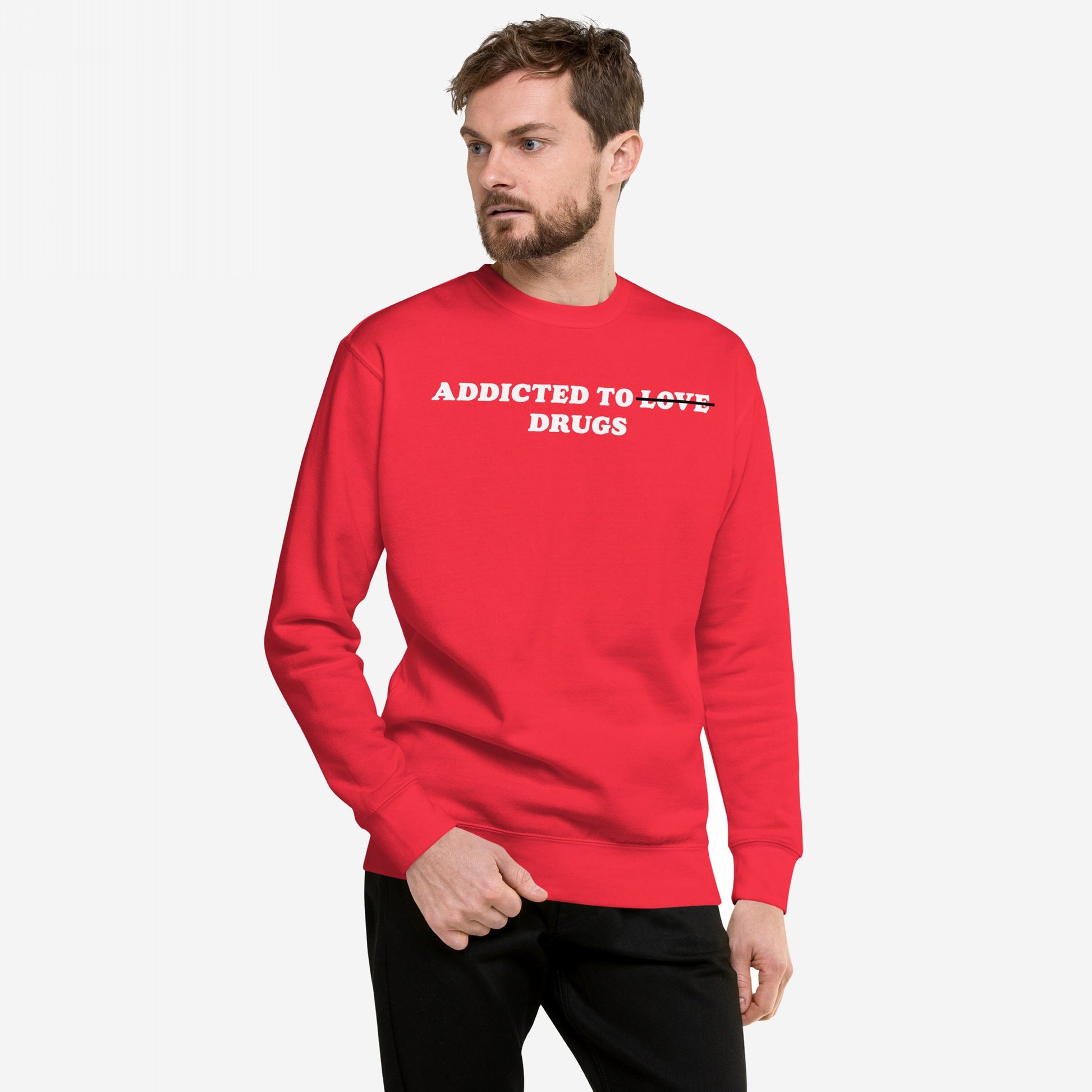 Male model in a red Addicted To Love / Drugs Sweatshirt EU, showcasing bold white text humorously replacing LOVE with DRUGS on the chest, embodying Egoproof's candid mental health message.