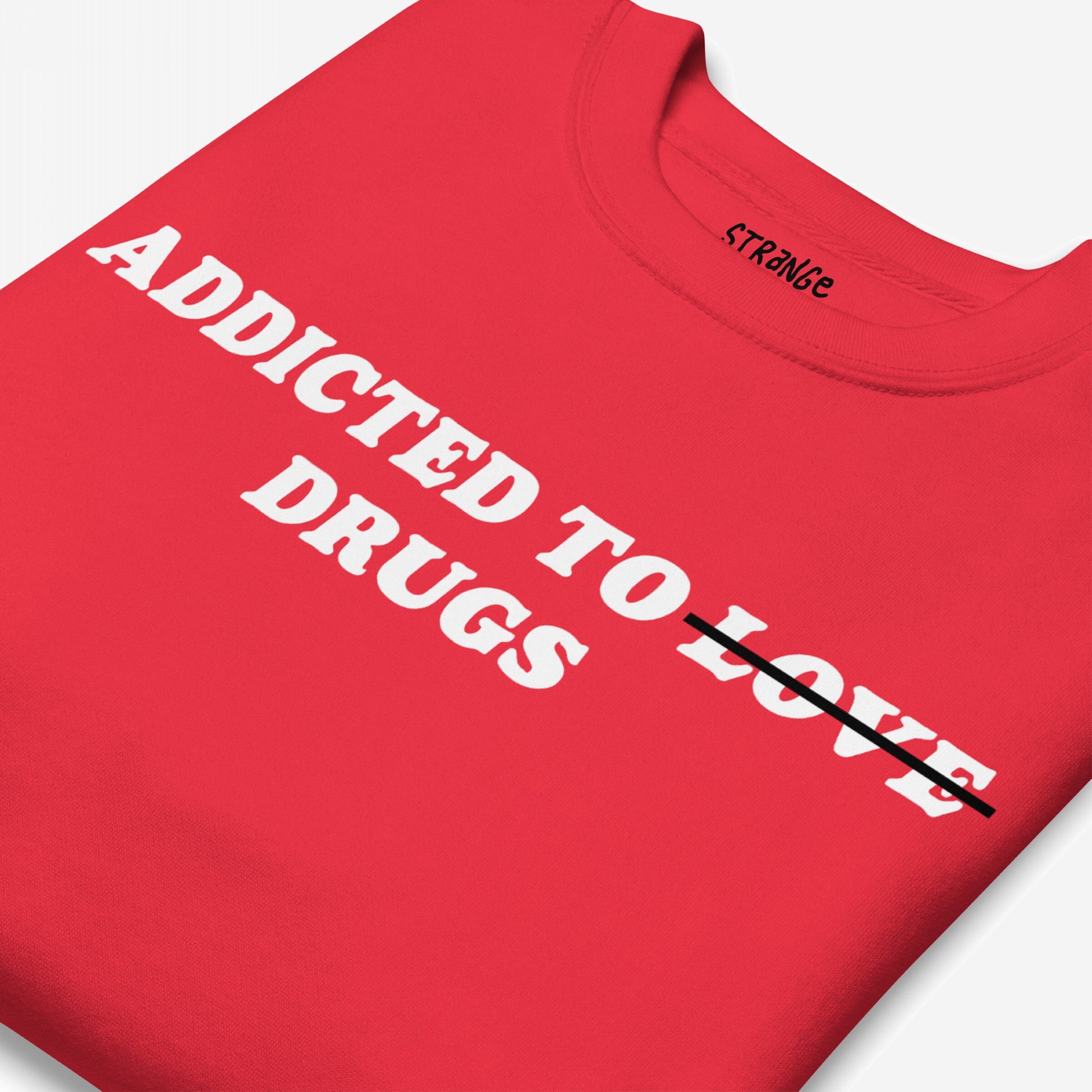 Folded Addicted To Love / Drugs Sweatshirt EU featuring a bold white slogan altered with black strike-through, showcasing humor and honesty. Ideal for self-expression, linked to mental health support.