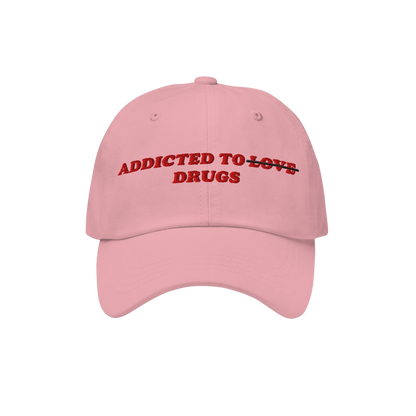 The Egoproof Addicted To Love / Drugs Hat features pink fabric with red embroidery—LOVE crossed out for DRUGS—making a bo