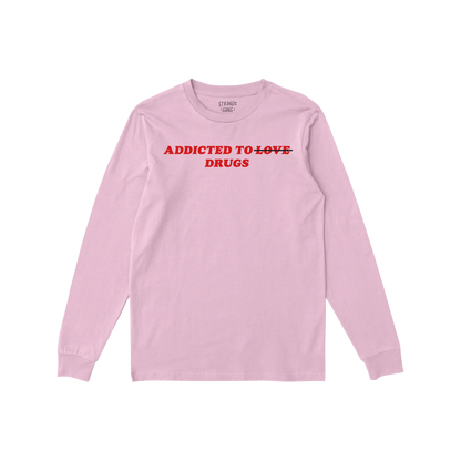 Addicted To Love / Drugs Long Sleeve T-shirt in pink with bold red text crossing out love and highlighting drugs on front.