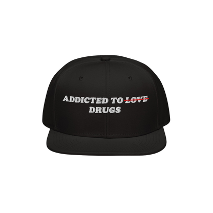 The Egoproof Addicted To Love / Drugs Hat is a black snapback with ADDICTED TO LOVE DRUGS embroidered on the front, LOVE cros