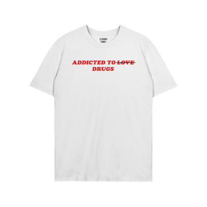 White unisex tee with bold red text "Addicted To Love" crossed out and replaced with "Drugs," titled Addicted To Love / Drugs