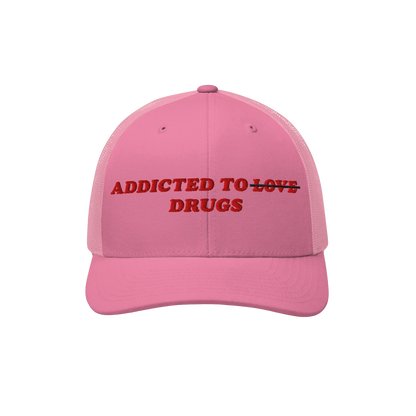 The Egoproof Addicted To Love / Drugs Hat is a bold pink snapback with red embroidery that says ADDICTED TO ~LOVE~ DRUGS, wit