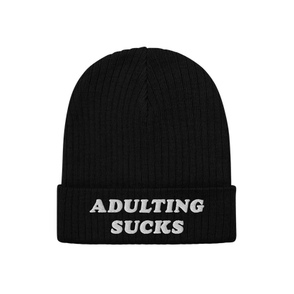 Black rib-knit beanie with folded cuff, featuring ADULTING SUCKS in white block letters. The Adulting Sucks Hat embodies a vi