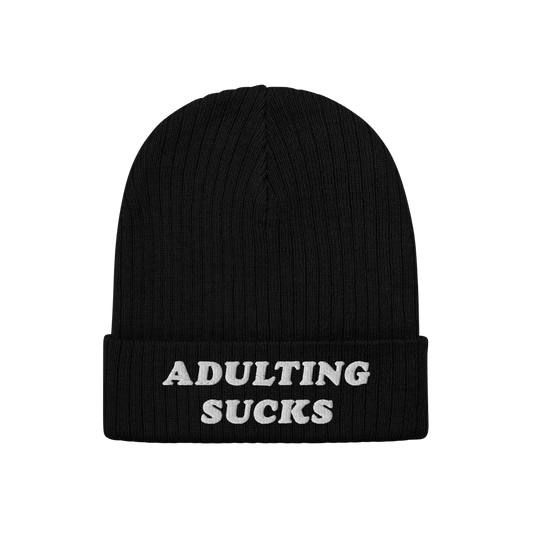 Black rib-knit beanie with folded cuff, featuring ADULTING SUCKS in white block letters. The Adulting Sucks Hat embodies a vi