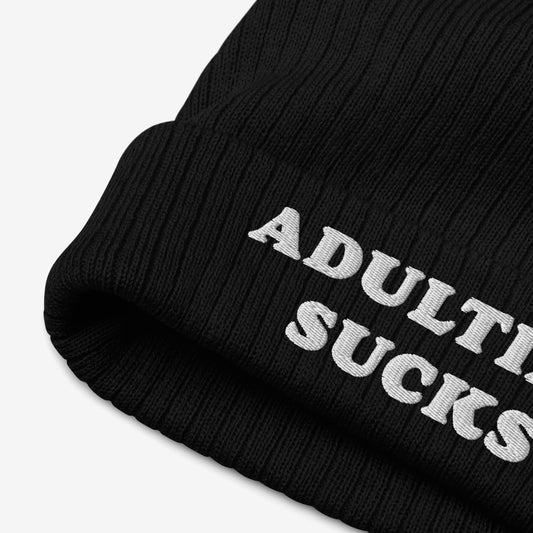Adulting Sucks Hat: A black rib-knit beanie with a folded cuff, featuring bold white embroidery that reads “ADULTING SUCKS.” Perfect for expressing frustration with adult responsibilities.