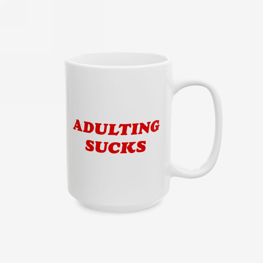 White ceramic Adulting Sucks Mug with bold red text, designed for office rebels and remote workers. Features a standard handle, sublimated print, and shiny finish. Dishwasher-safe; available in 11 oz. and 15 oz.