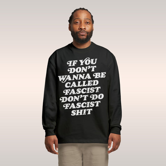 Young man models the Anti-Fascist T-shirt with bold slogan, advocating accountability. Paired with light-green cargo pants, t