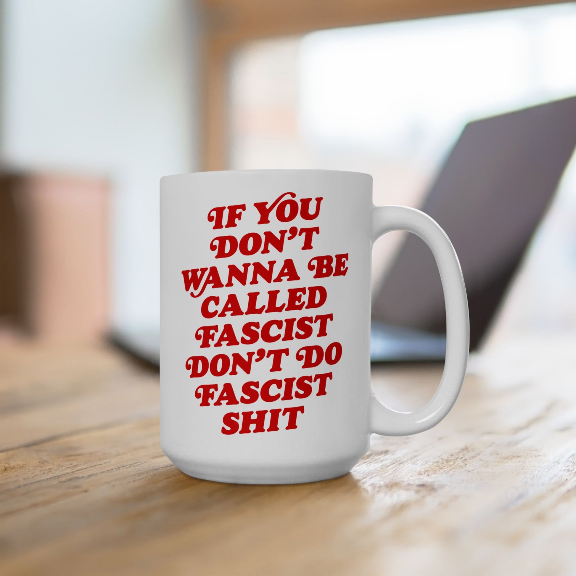 Anti-Fascist Mug on a wooden table, featuring bold red text urging resistance against fascism. Ideal for coffee or tea, it embodies defiant style with a vintage touch, reflecting Egoproof's empowering ethos.