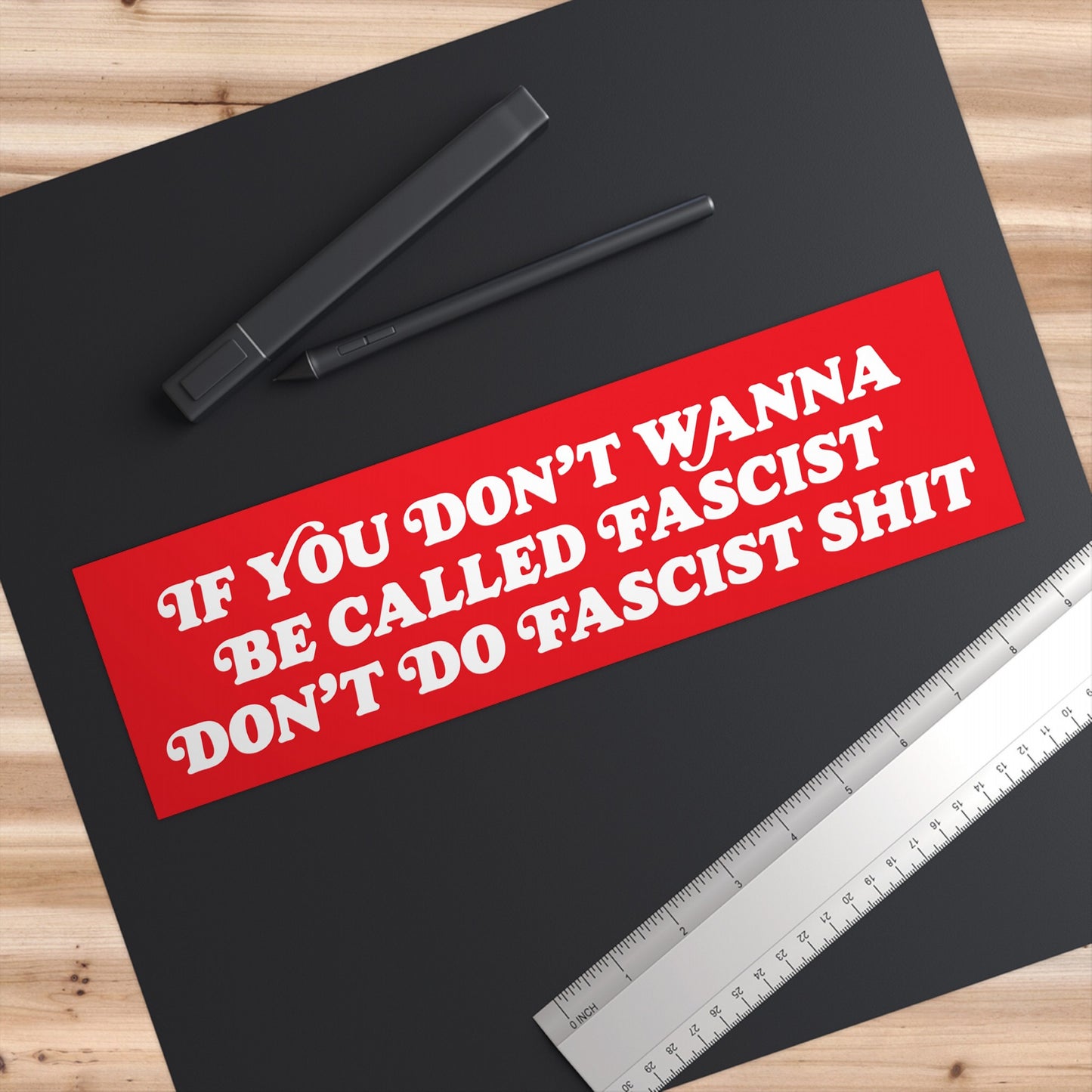 Anti-Fascist Sticker & Magnet on a designer's workspace with a drawing tablet, stylus, and ruler. The bold red design conveys a powerful, unapologetic message against oppression and fascism.