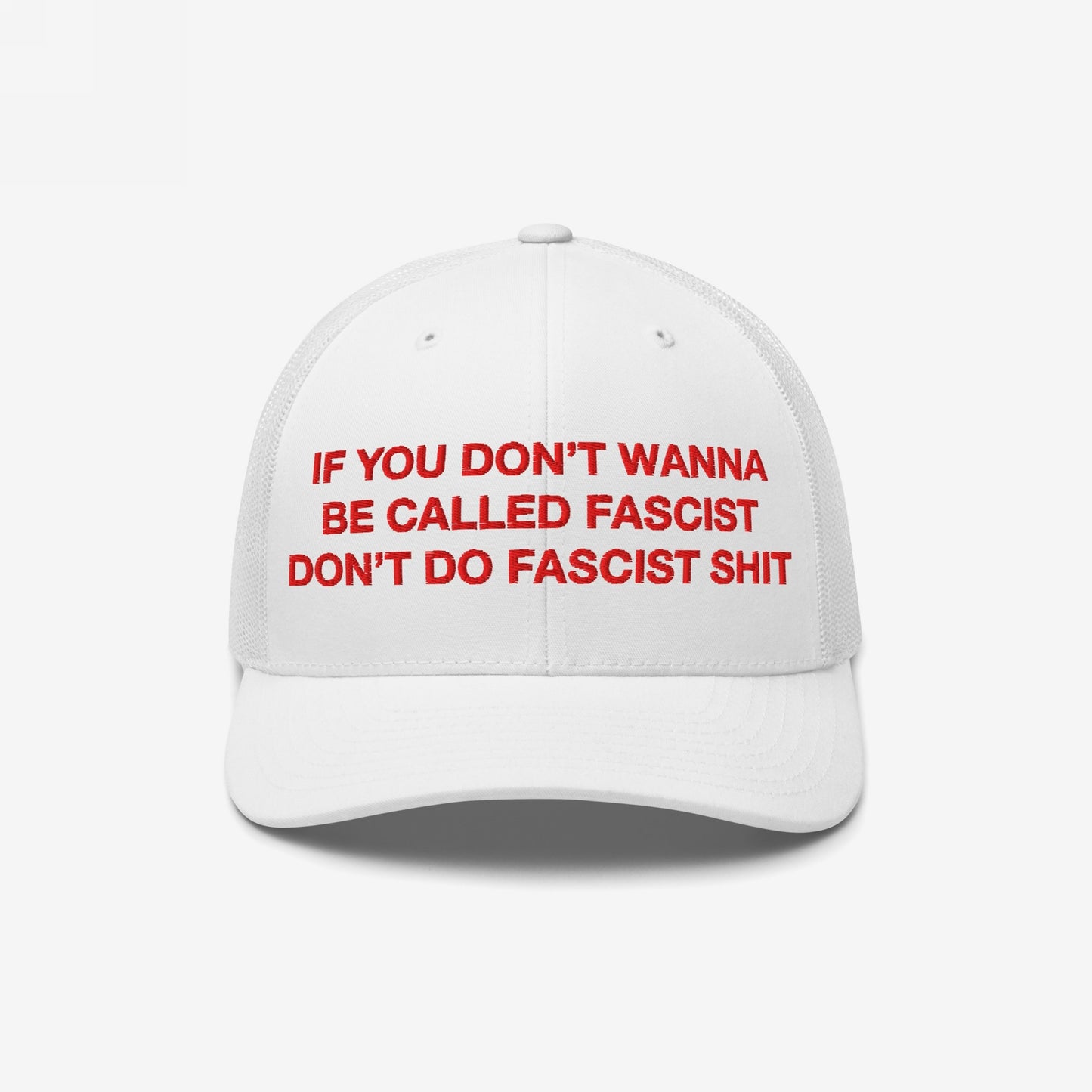 Anti-Fascist Hat featuring bold red embroidery of the slogan, If you don’t wanna be called fascist, don’t do fascist shit, on a trucker-style cap with a white mesh back.