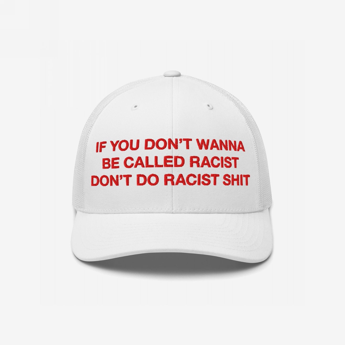 White trucker-style baseball cap with red text reading “If you don’t wanna be called racist don’t do racist shit.”, embodying the Anti-Racist Hat EU's bold, rebellious message against hate.