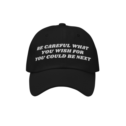 Black six-panel Be Careful Hat with a curved brim, featuring bold off-white embroidery: “BE CAREFUL WHAT YOU WISH FOR YOU C