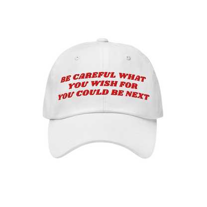 Be Careful Hat with bold red embroidery, stating “BE CAREFUL WHAT YOU WISH FOR YOU COULD BE NEXT”, embodies a bold, unapo