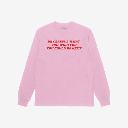 Be Careful Long Sleeve T-shirt in pink with bold red typography reading "Be Careful What You Wish For You Could Be Next" on the back.