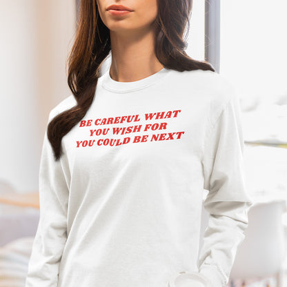 Woman wearing a white Be Careful Long Sleeve T-shirt with red bold text reading "Be Careful What You Wish For You Could Be Next.