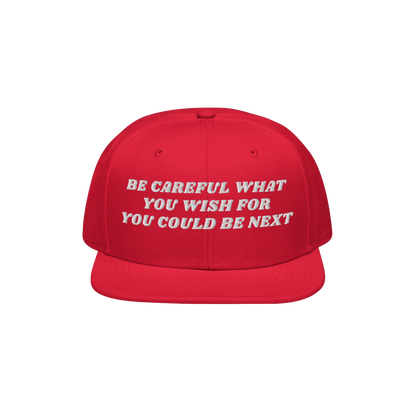 Bright red snapback cap with the bold white embroidered text BE CAREFUL WHAT YOU WISH FOR YOU COULD BE NEXT., titled Be Caref