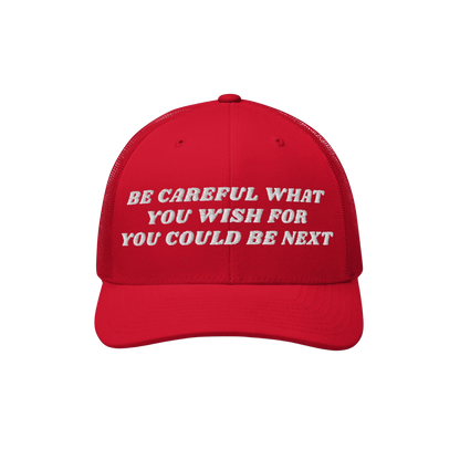 Red mesh-back trucker hat with white embroidery reading the bold message: “BE CAREFUL WHAT YOU WISH FOR YOU COULD BE NEXT.�