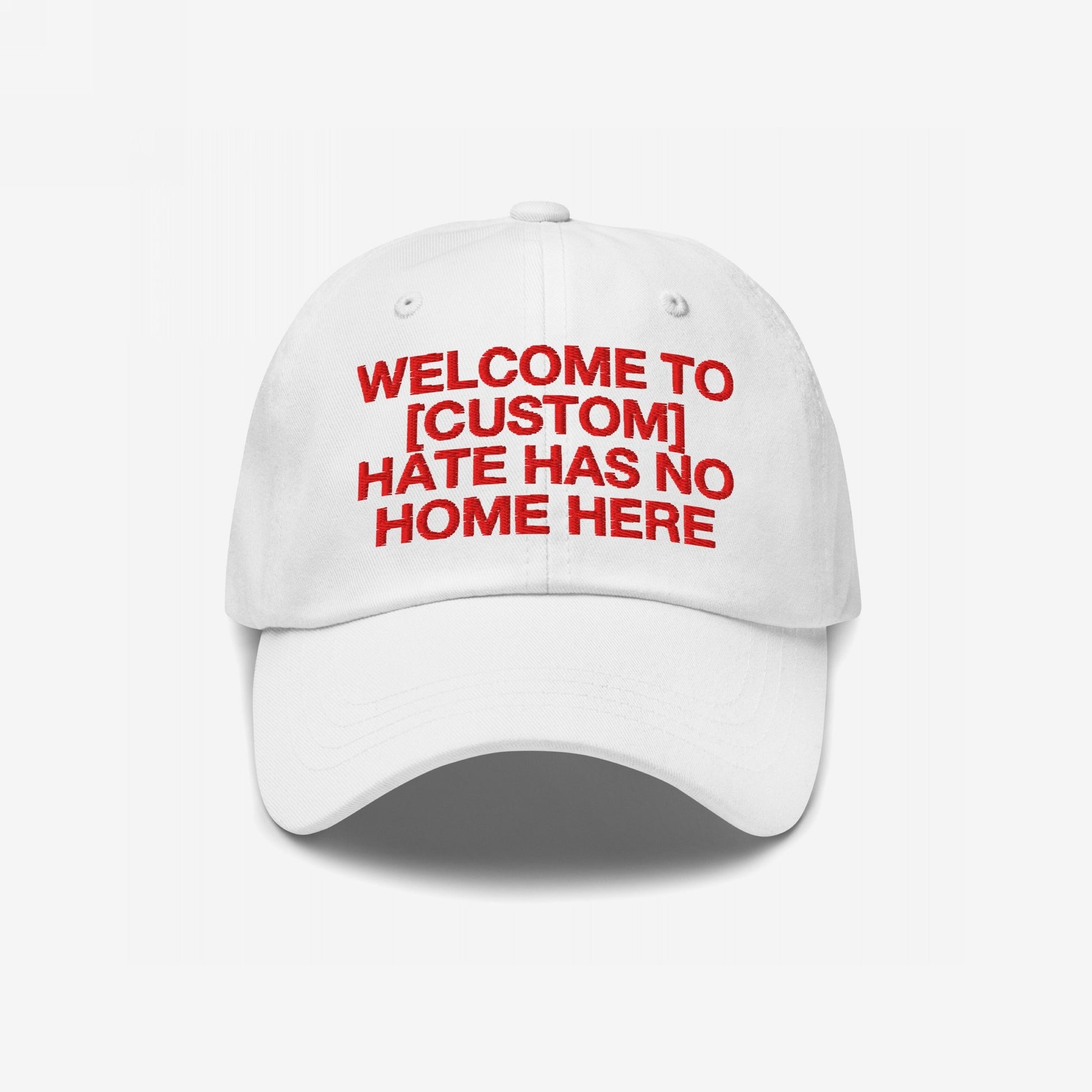 White Custom Hate Has No Home Here Dad Hat with red embroidered bold text promoting love and inclusivity, adjustable strap and classic fit.