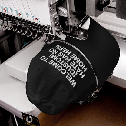 Custom Hate Has No Home Here Dad Hat in black being embroidered with bold white text on adjustable chino cotton cap
