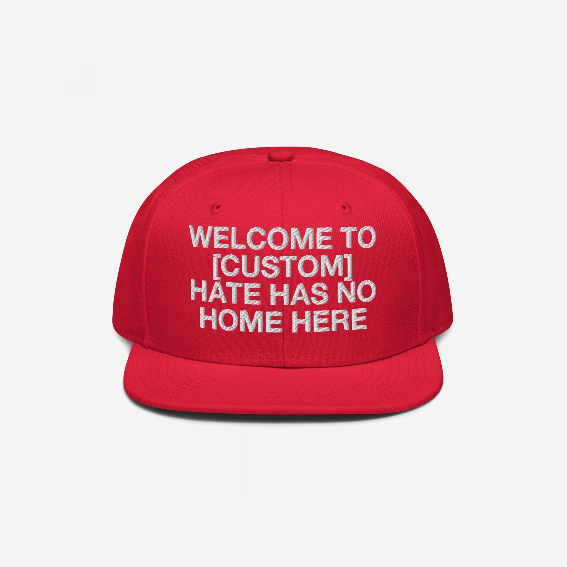 Custom Hate Has No Home Here Snapback Hat in red with bold white embroidery and flat bill, promoting inclusivity and customizable text.