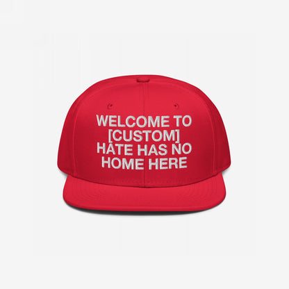 Custom Hate Has No Home Here Snapback Hat in red with bold white embroidery and flat bill, promoting inclusivity and customizable text.
