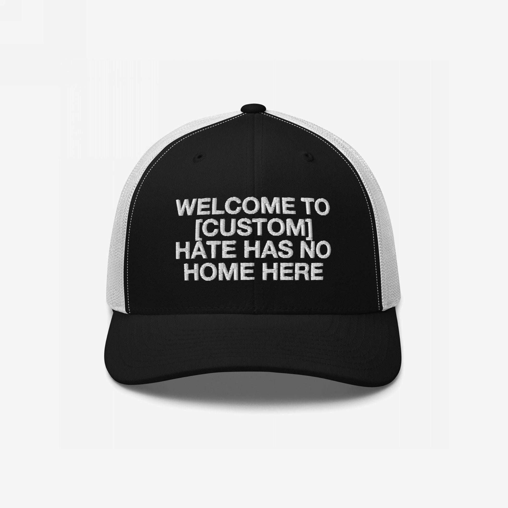 Custom Hate Has No Home Here Trucker Hat in black with white mesh back featuring customizable bold message on front panel