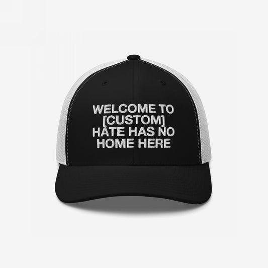 Custom Hate Has No Home Here Trucker Hat in black with white mesh back featuring customizable bold message on front panel
