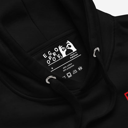 Close-up of Fucks To Give Hoodie EU's neck, showing label with EGO PROOF, size S, and fabric details. Includes care icons, drawcord, and metal eyelet. Cozy mental health statement wear.