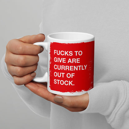 A person holds the Fucks To Give Mug, featuring bold white text on a red rectangle, humorously indicating an emotional inventory check. Perfect for expressing mental resilience with each sip.