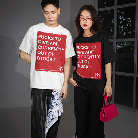 Two young models showcase the Fucks To Give T-shirt, featuring bold text in a red square. The man wears a white tee; the woman, a black one, both embodying streetwear style.