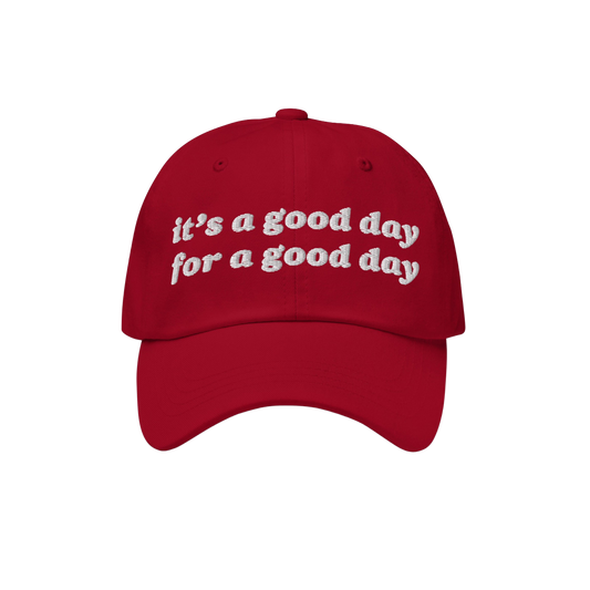 Red baseball-style Good Day Hat with white embroidered text reading, “it’s a good day for a good day.” Ideal for positi