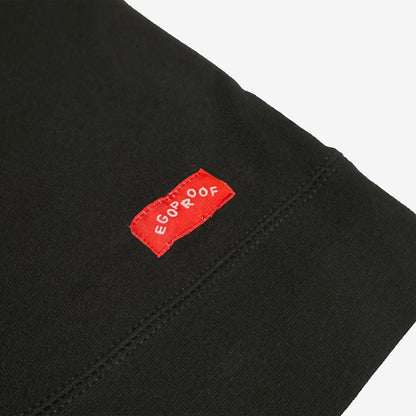 The Good Day Sweatshirt features a close-up of its hem with a small red woven EGOPROOF label, embodying subtle positivity in line with Egoproof’s mental health-focused apparel ethos.