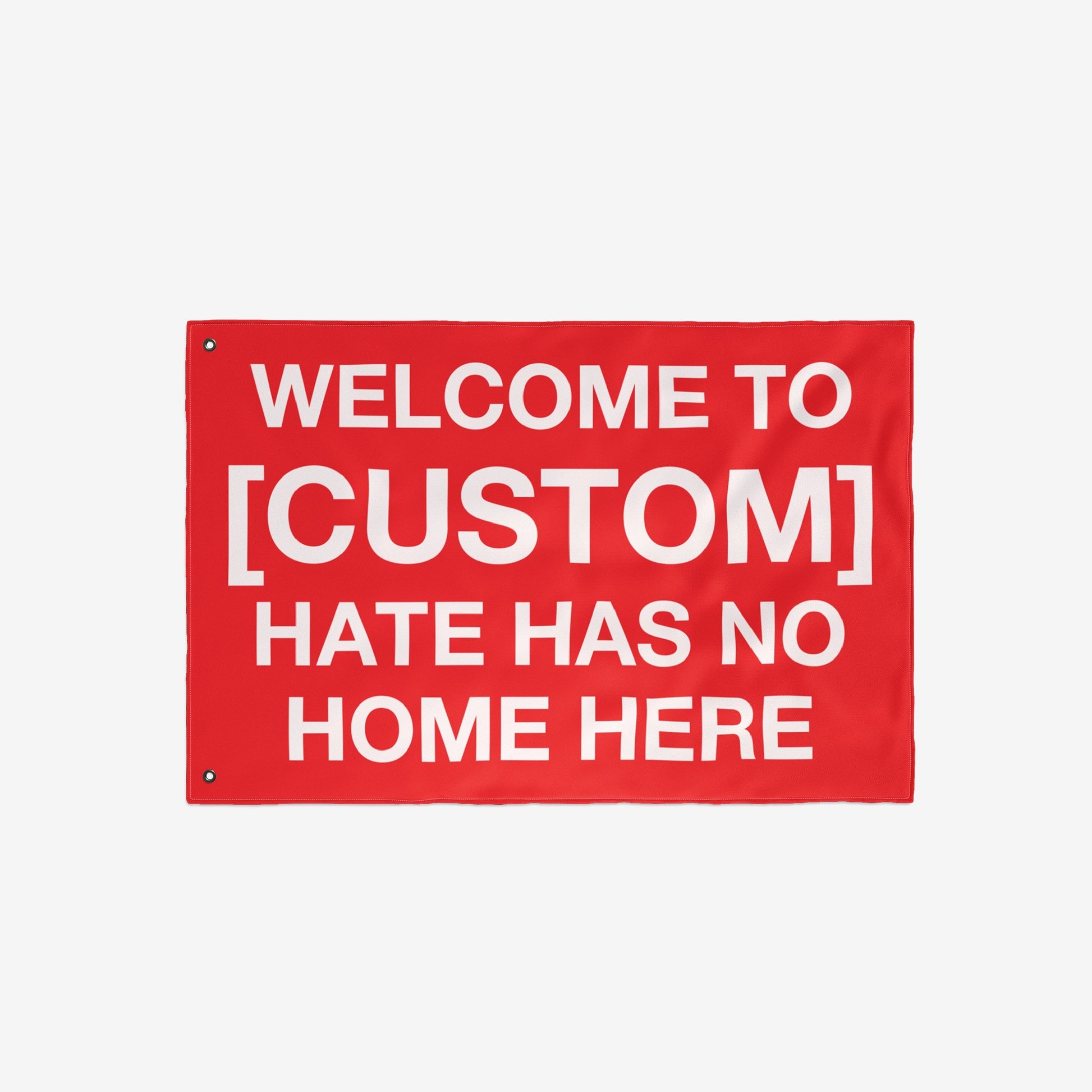 Custom Hate Has No Home Here Flag with bold white text on a red background, featuring metal grommets for hanging. Designed for promoting acceptance and unity in homes, rallies, and public spaces.