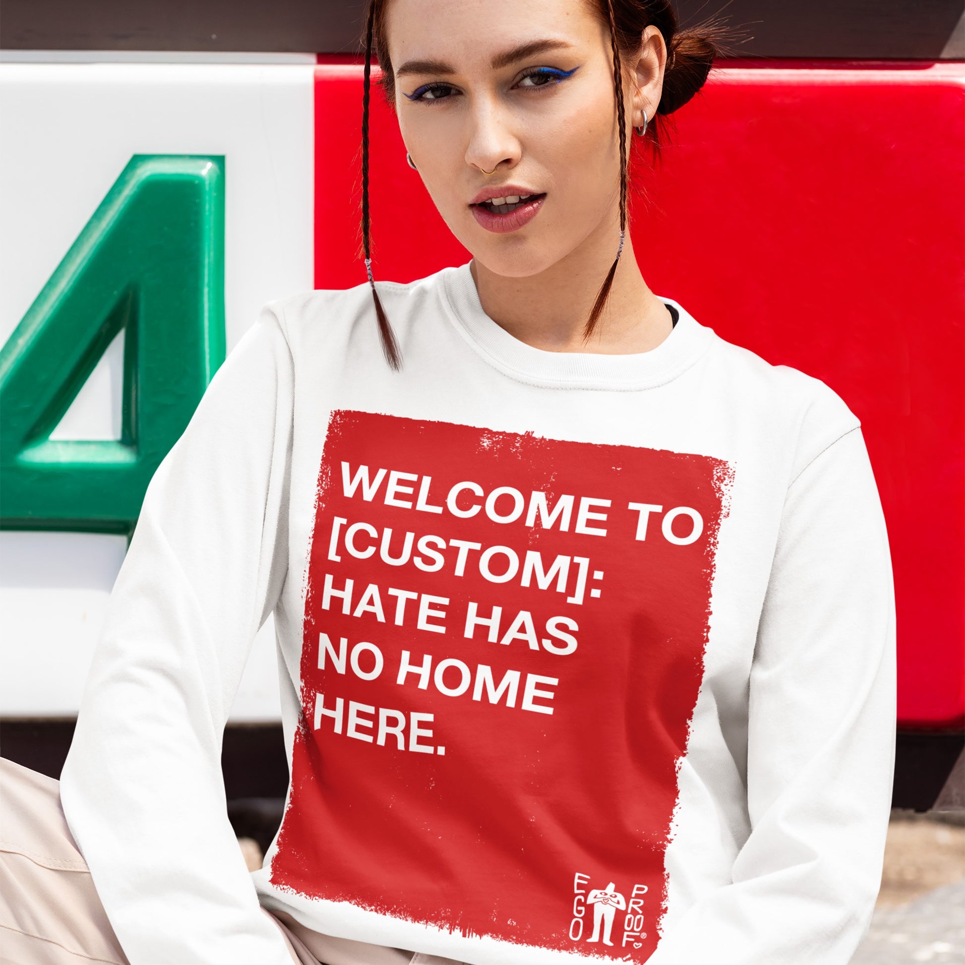 Custom Hate Has No Home Here Long Sleeve T-shirt features a bold red rectangle with white text advocating against hate. The design is customizable, allowing personal expression of values and community pride.