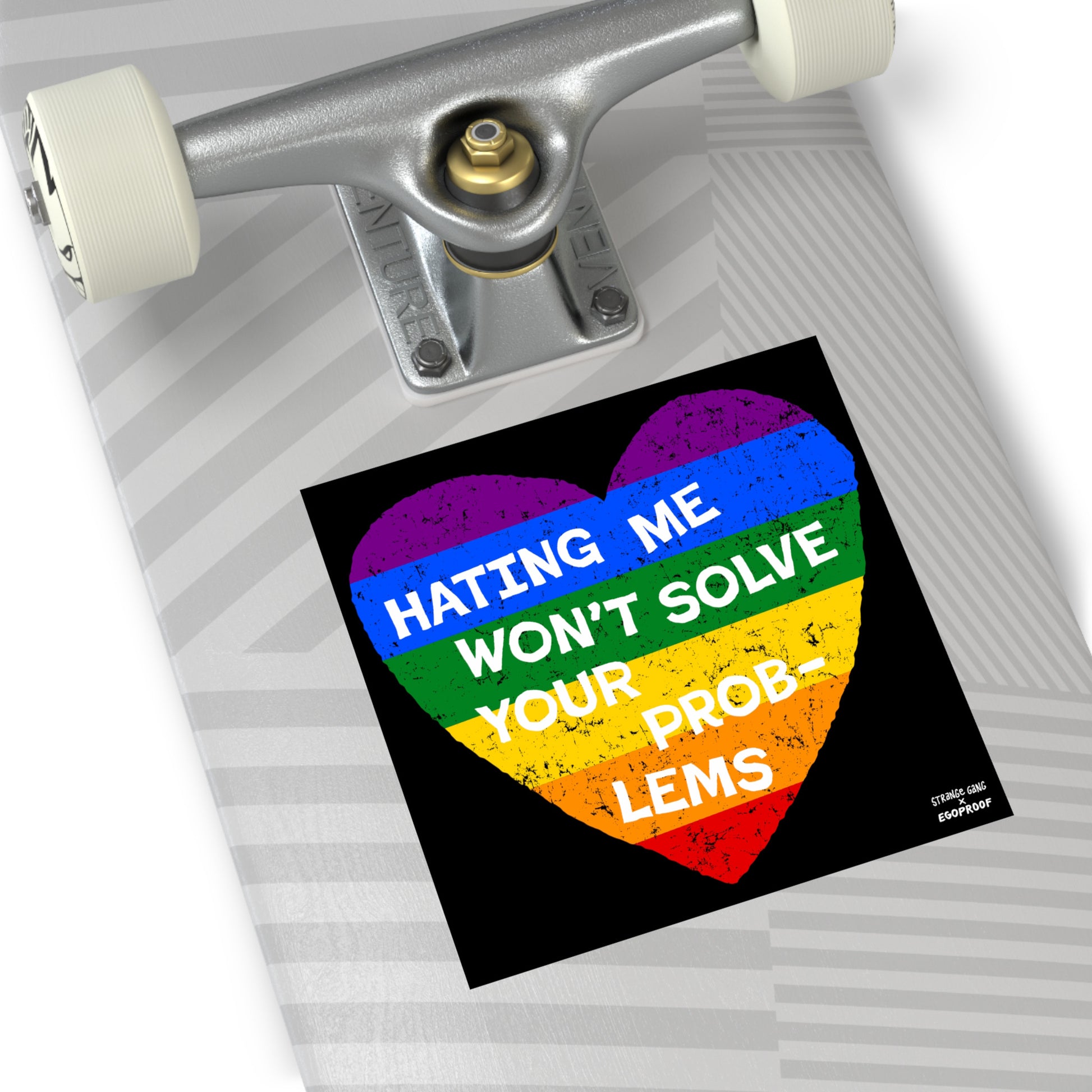 No LGBTQ Hate Sticker & Magnet with rainbow heart and text "Hating Me Won’t Solve Your Problems" on skateboard surface.