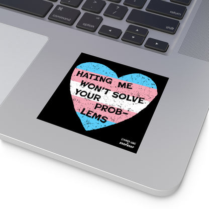No Trans Hate Sticker & Magnet showing trans flag heart with "Hating Me Won't Solve Your Problems" on laptop surface.