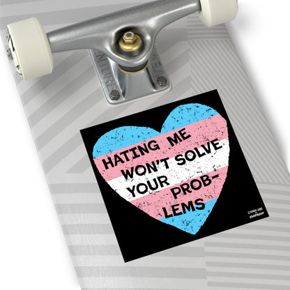 No Trans Hate Sticker & Magnet displaying trans flag heart with "Hating Me Won’t Solve Your Problems" on skateboard deck.