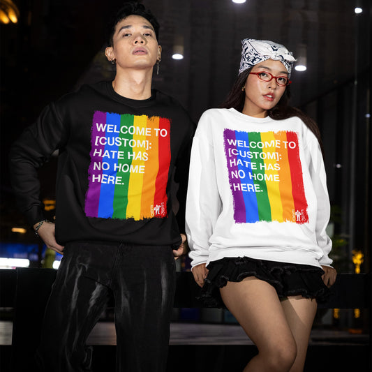 Custom Hate Has No Home Here Pride Sweatshirt: Two young adults model black and white sweatshirts with rainbow graphics and inclusive text, embodying the brand's message of equality and anti-hate.