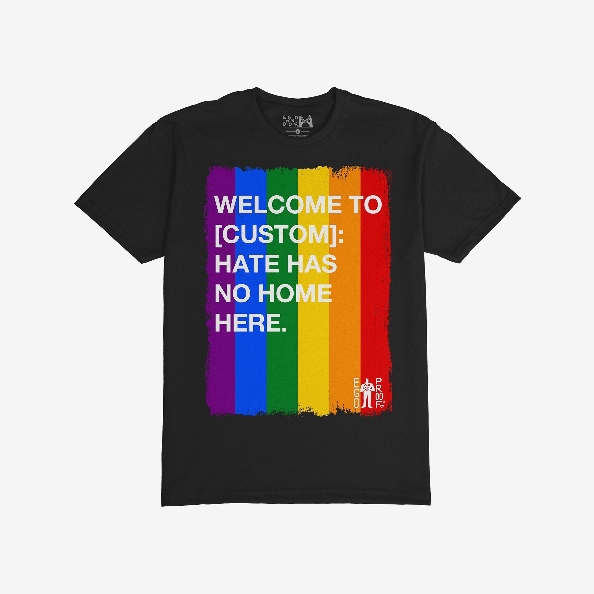 Custom Hate Has No Home Here Pride T-shirt featuring bold white text over rainbow stripes, customizable with your community name. Ideal for promoting unity and acceptance. Includes a small EGO PROOF logo.