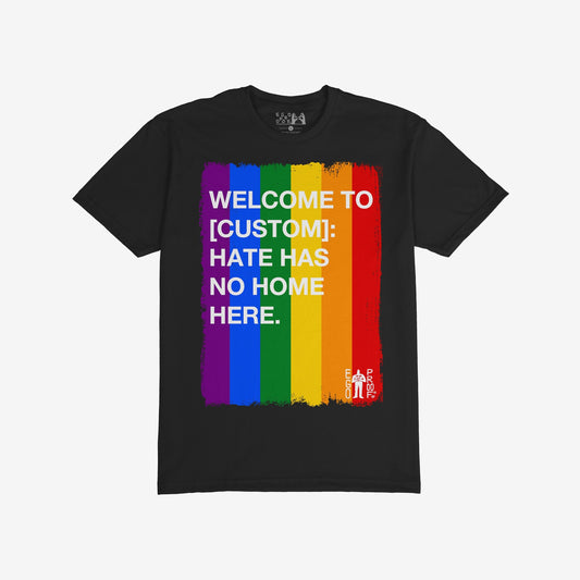 Custom Hate Has No Home Here Pride T-shirt featuring bold white text over rainbow stripes, customizable with your community name. Ideal for promoting unity and acceptance. Includes a small EGO PROOF logo.