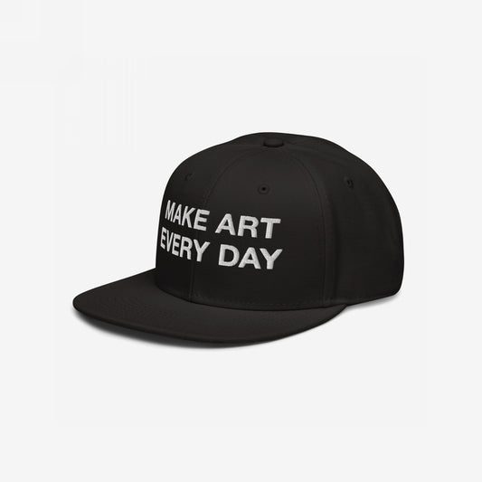 Make Art Every Day Hat: Black snapback cap with 'MAKE ART EVERY DAY' embroidered in white on the front, embodying creativity and persistence. Features EGOPROOF embroidery, adjustable fit, perfect for artistic expression.