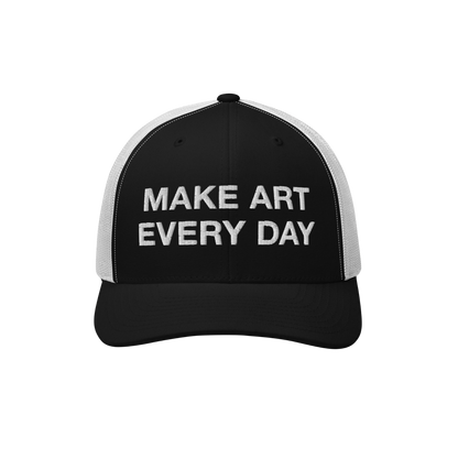 The Make Art Every Day Hat features a black-and-white mesh-back design with a black front panel, embroidered with “MAKE ART