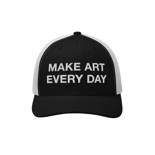 The Make Art Every Day Hat features a black-and-white mesh-back design with a black front panel, embroidered with “MAKE ART