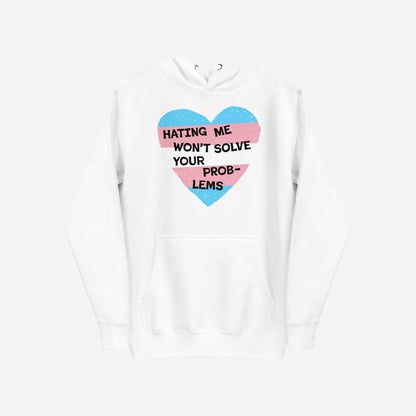 White No Trans Hate Hoodie EU featuring a distressed heart graphic with sky-blue and pastel-pink bands and the slogan “Hating Me Won’t Solve Your Problems” across the chest, symbolizing resistance and pride.