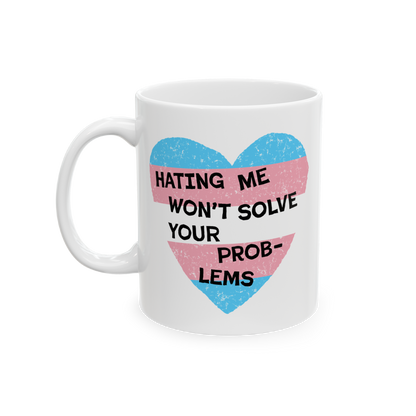 Close-up of the No Trans Hate Mug featuring a pastel-striped heart and the quote, “Hating Me Won’t Solve Your Problems,��